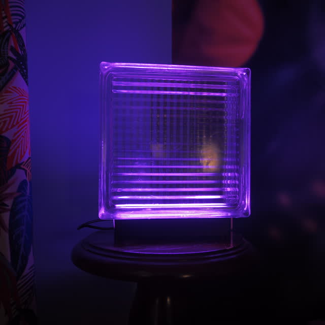Purple lamp on a round wooden stand